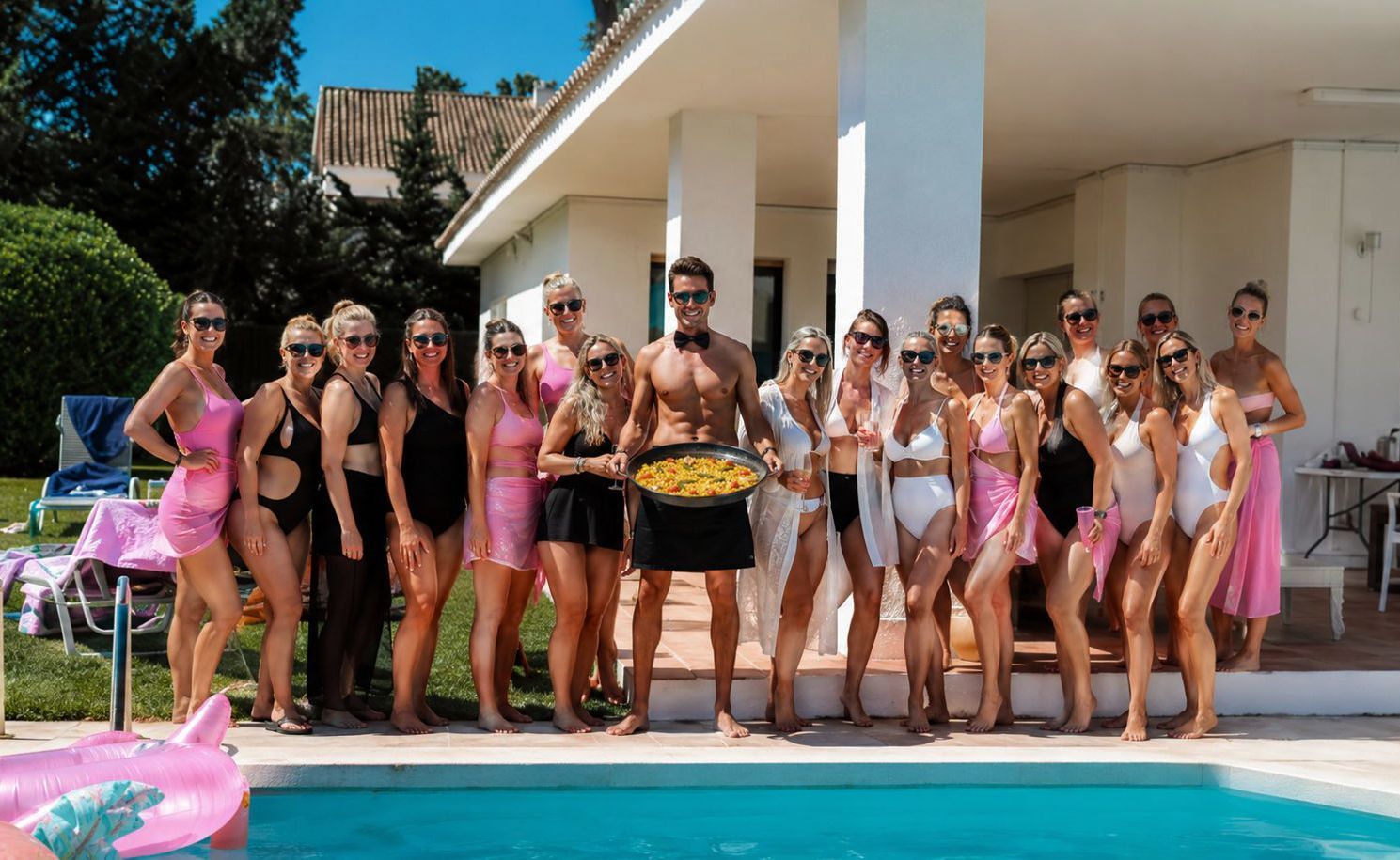 Hen party group with a fresh paella by the pool at a Marbella villa