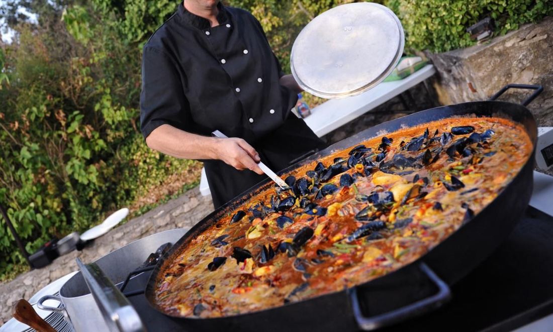 Chef cooking a large paella at a Marbella villa